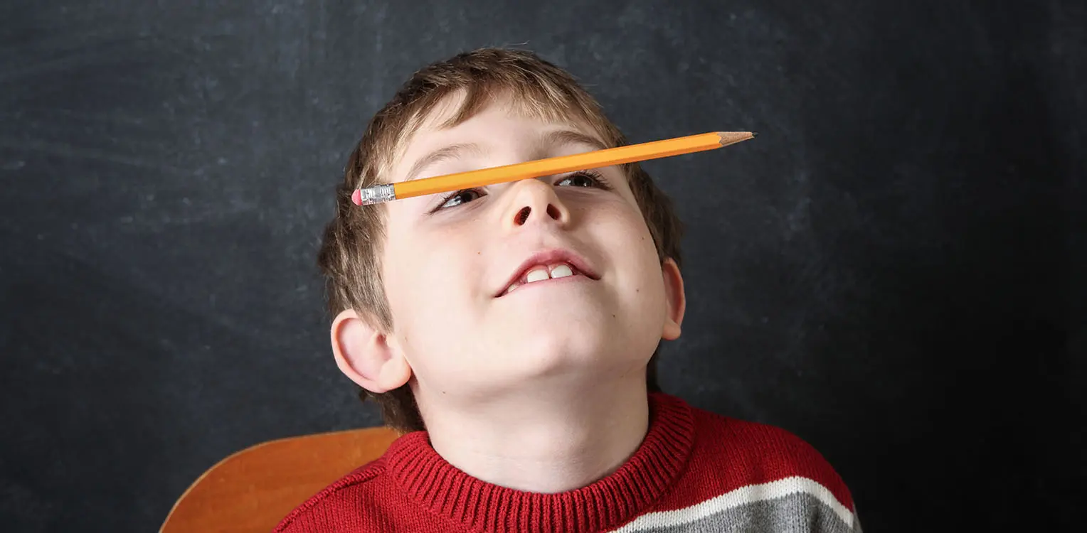 Child with ADHD balancing pencil on nose